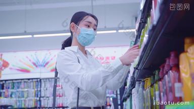 戴口罩的青年女人在超市选购洗护用品